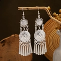 Detail of silver ethnic leaf tassel earrings hanging on branch in rustic bohemian style - Round Sun Totem Tassel