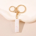 Porte-clés doré avec pendentif en résine et paillettes holographiques roses et bleues - Lettre I