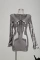 Détail d'une robe argentée à paillettes avec manches longues et lacets noirs au décolleté - S / Argent
