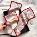 Pink marble pattern silk scarf with red edges draped over a luxury gift box - Tie-dye Quicksand