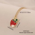 Dettaglio collana con ciondolo a fragola dorata con smalto rosso e verde brillante - Fragola