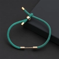 Détail du bracelet tressé vert émeraude avec fermoir coulissant doré et finitions chic - Vert