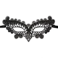 Close-up of black lace eye mask with intricate hollow patterns and ribbon ties - Small Peacock