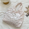 Détail du sac bandoulière en soie rose avec motif ours et nœud texture soyeuse - Rose