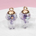 Detail of two transparent astronaut glass pendants with purple glitter on a white plate - Astronaut / Light Purple
