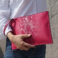 Detailed view of pink snakeskin pattern PU leather envelope clutch with wristlet strap - Rose Red