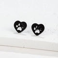 Detailed close-up of heart-shaped black steel stud earrings with hollow cat paw cutouts - 439 Black (Heart Paw)