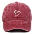 Dettaglio del ricamo bianco con cuore e croce su un cappellino in cotone lavato bordeaux - Taglia unica / Borgogna