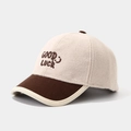 Dettaglio del ricamo Good Luck su cappellino bicolore in lana e velluto a coste per bambini - Ricamo Good Luck / Bianco Sporco