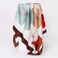 Close-up of printed satin silk scarf with abstract floral patterns and brown edges - 90x90cm / Light Green (D9223)