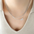 Collana a doppio strato in argento con ciondolo Love e cuore indossata da una modella - Argento