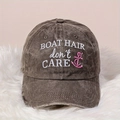 Washed black vintage baseball cap with BOAT HAIR embroidery on a plush white surface - Coffee