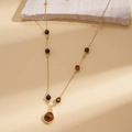 Detail view of retro gold flower necklace with tiger eye beads on natural stone background - Necklace-Brown Tiger Eye