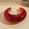 Primer plano de un brazalete de resina rojo oscuro con un acabado pulido y un diseño grueso - Rojo Translúcido