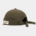 Detail of olive green docker hat featuring a metal ring and fabric slogan label - Adjustable / Ring Letter Patch Olive Green