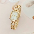 Detalle macro de un reloj dorado cuadrado con esfera blanca y cuatro marcadores de diamante - Dorado