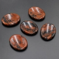 Five polished oval tiger eye stones for facial guasha massage on a dark background - Gold Swan Stone (1pc)