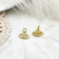 Macro shot of gold-plated evil eye pendants with sparkling white zircon on white lace - Blue Eye with Lashes