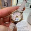 Elegant ladies quartz watch with gold diamond bezel and white leather strap on wrist - Off White