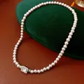 Vintage pearl necklace with square zircon pendant displayed on a green velvet jewelry box - Pink Necklace