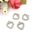 Vista ravvicinata di quattro ciondoli a cuore d'argento con elementi decorativi - Ciondolo a Cuore 12x13mm