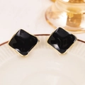 Detail of irregular square stud earrings with black enamel and gold-plated metallic borders - Black