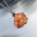 Collier long avec un dé d20 orange logé dans une cage en maille métallique argentée - Cage d'argent avec dé orange