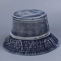 Detailed close-up of washed denim bucket hat fabric and engraved metal brand plate - M (56-58cm) / Dark Blue