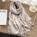 Elegant beige cashmere feel scarf with fringe details and a small label on soft carpet - Off-White Grey