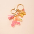 Portachiavi lettera F rosa con nappa, farfalla e paillettes a cuore dorate lucide - Lettera F
