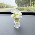 Car air freshener bottle with white artificial flowers on dashboard with liquid - White Gypsophila