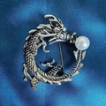 Detailansicht einer Vintage Silber-Drachenbrosche mit Schuppen und weißen Perlen - Drache Hält Weiße Perle
