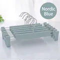 Close-up of ten Nordic blue non-slip plastic pants hangers with adjustable clips and metal hooks - Nordic Blue