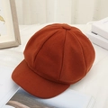 Detailed close-up of caramel wool newsboy hat texture and fabric on a white cloth - Caramel color