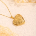 Detailansicht des Herz-Medaillons mit Vintage-Blumengravur und goldener Kette - Blumen Herz / Gold