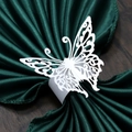 Detail of laser-cut white butterfly paper napkin ring on a dark green satin cloth - White