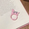 Détail d'une bague chiot rose avec collier de perles et nœud en zircon sur livre - Style ouvert réglable / Chien Rose
