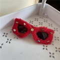 Detail of red plush heart sunglasses frame with colorful rhinestones on a white tray - Red