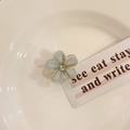 Delicate light blue floral hair claw clip with gold edges and crystal center on ceramic plate - Blue Flower