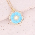 Dettaglio ravvicinato del ciondolo ottagonale in oro con smalto blu e motivo sole - Stile Ottagono Sole Smalto Blu (3#)