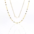 Detail of layered gold titanium necklace with a white gemstone and textured ripple chains - Moonstone