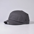 Detail view of a dark grey five-panel camper hat with metal eyelets and premium stitching - Dark Gray
