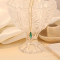 Collana con ciondolo a foglia dorata con cristalli verdi e bianchi su supporto in vetro - Verde