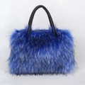 Detailed close-up of blue faux fur tote bag with black leather straps and top zipper closure - Blue