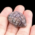 Miniature amethyst hedgehog stone carving held by hand to show compact size - India Agate