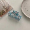 Close-up of a large blue and pink marbled acetate hair claw clip with a hollow rectangular design - Large Square Claw / Pale Blue