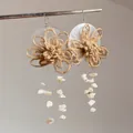 Gros plan détaillé de boucles d'oreilles tressées à fleurs avec éclats de coquillages - 14# Crochet d'oreille - Blanc marron (Fleur en coquillage tissé)