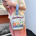 Blue striped canvas tote with animal prints and circular wooden handle on a model - Animal Pear Journal