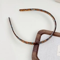 Détail d'un serre-tête en acétate écaille de tortue avec motifs bleus sur support bois - Dégradé bleu marron