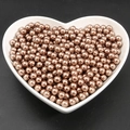 Metallic bronze round imitation pearls in a white heart bowl for DIY crafts - Brown